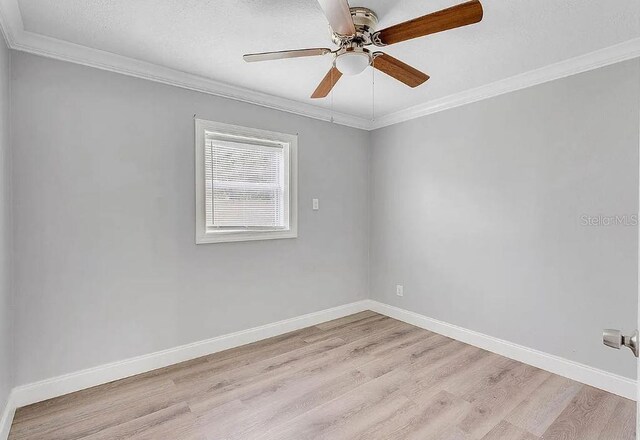 empty room featuring ceiling fan, ornamental molding, light hardwood / wood-style floors, and a textured ceiling