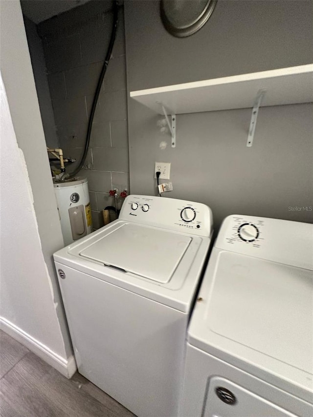 laundry room featuring hardwood / wood-style floors, electric water heater, and washing machine and clothes dryer