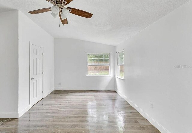 interior space featuring vaulted ceiling, ceiling fan, light hardwood / wood-style flooring, and a textured ceiling