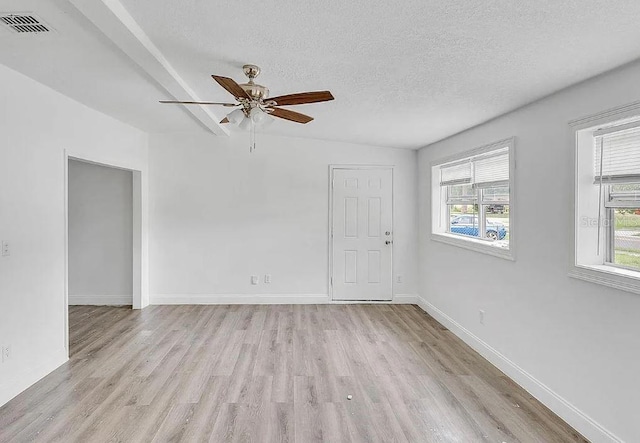 unfurnished room with ceiling fan, plenty of natural light, a textured ceiling, and light wood-type flooring