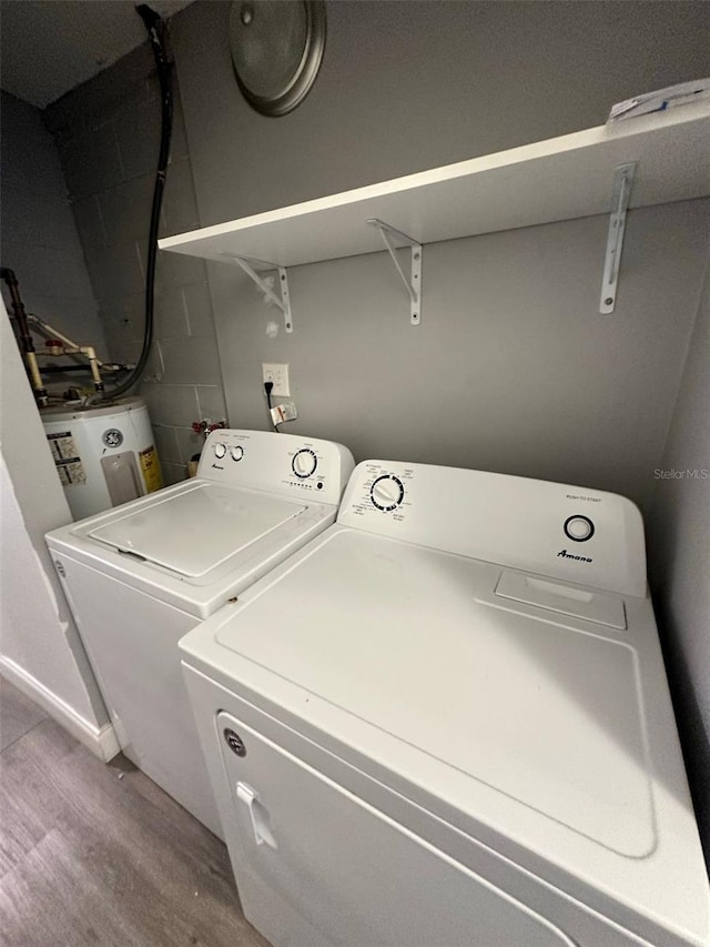 washroom featuring hardwood / wood-style flooring, water heater, and independent washer and dryer