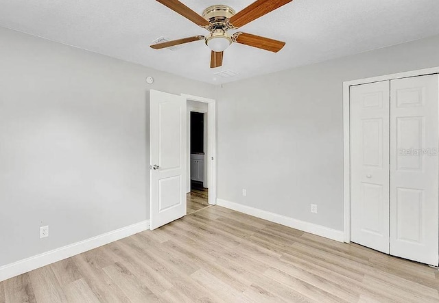 unfurnished bedroom with light wood-type flooring, a closet, and ceiling fan