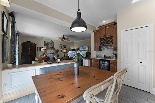 dining space featuring ceiling fan and beverage cooler