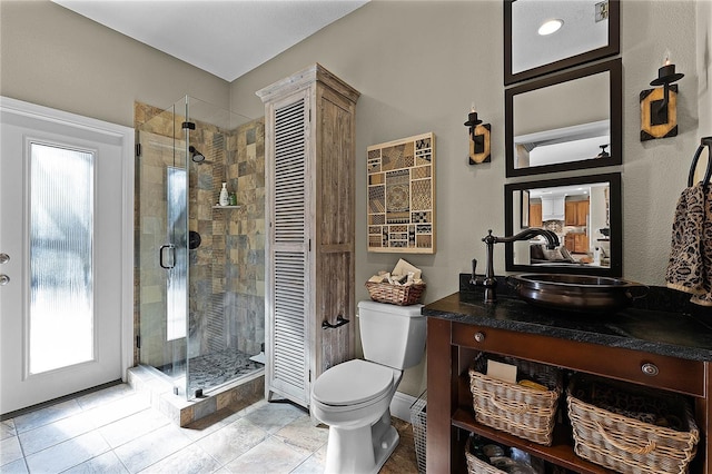 bathroom with toilet, a shower with shower door, and vanity