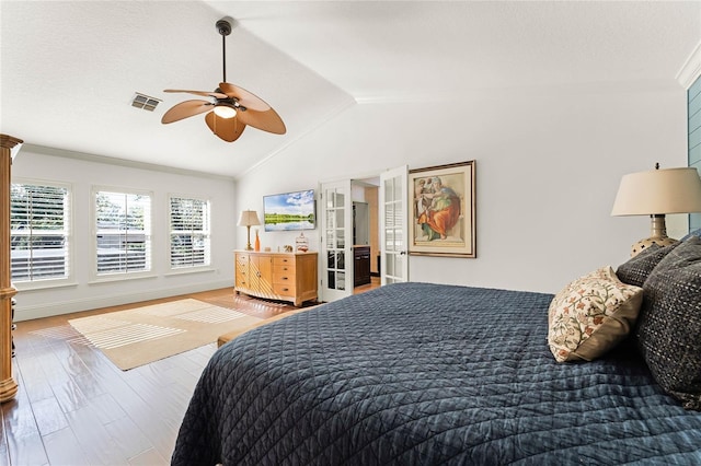 bedroom with ceiling fan, hardwood / wood-style floors, crown molding, and vaulted ceiling