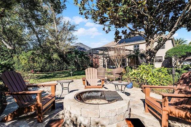 view of patio with a lanai and a fire pit