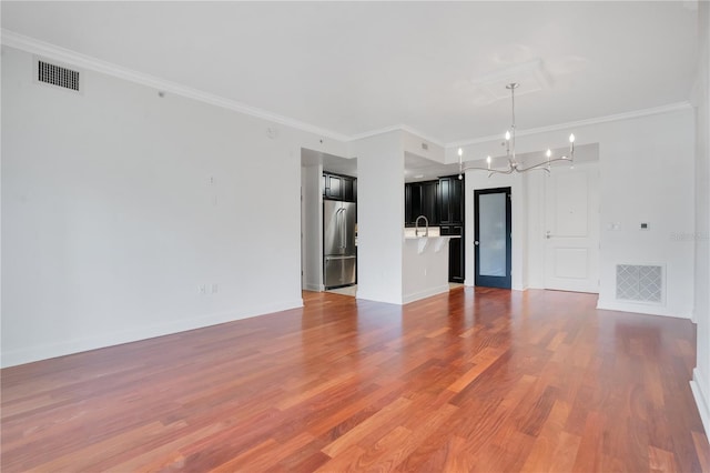 630 Vassar St Unit 2310, Orlando, FL 32804 - unfurnished living room featuring an inviting chandelier, sink, ornamental molding, and hardwood / wood-style floors