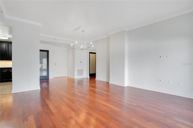 630 Vassar St Unit 2310, Orlando, FL 32804 - empty room featuring ornamental molding, hardwood / wood-style floors, and a notable chandelier