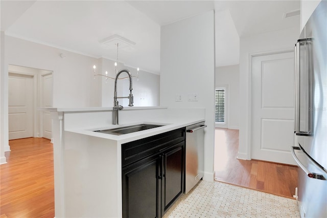 630 Vassar St Unit 2310, Orlando, FL 32804 - kitchen with sink, stainless steel appliances, kitchen peninsula, and light wood-type flooring