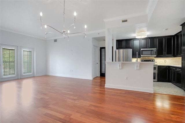 630 Vassar St Unit 2310, Orlando, FL 32804 - kitchen with ornamental molding, stainless steel appliances, a kitchen island, and light wood-type flooring