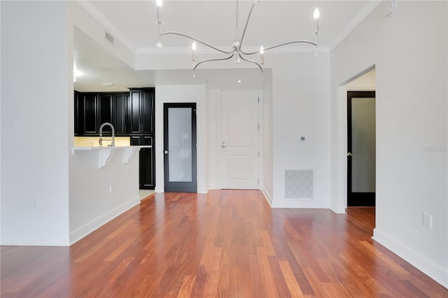 630 Vassar St Unit 2310, Orlando, FL 32804 - kitchen with ornamental molding, sink, a breakfast bar, and hardwood / wood-style floors