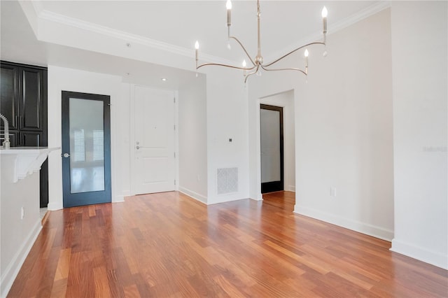 630 Vassar St Unit 2310, Orlando, FL 32804 - unfurnished dining area with crown molding, a notable chandelier, and light wood-type flooring