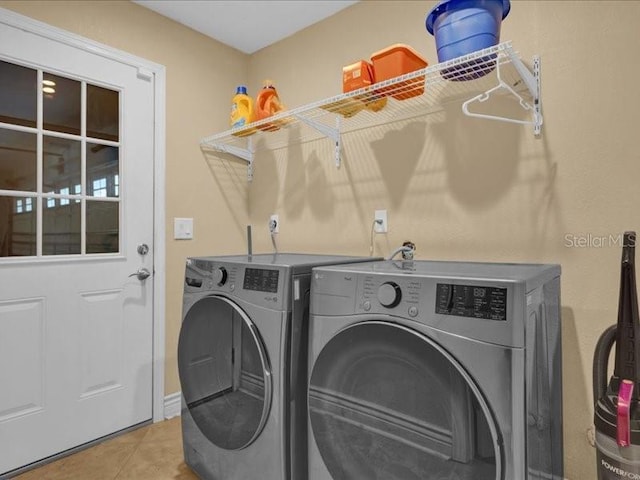 clothes washing area featuring tile patterned floors and separate washer and dryer