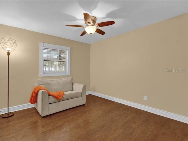 sitting room with hardwood / wood-style floors and ceiling fan