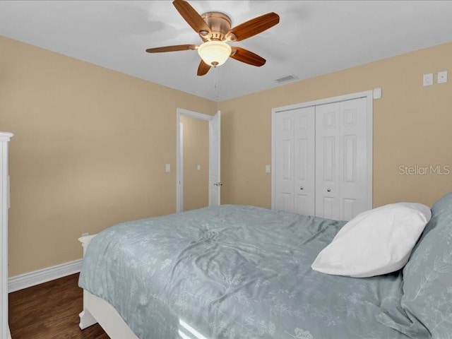 bedroom with dark hardwood / wood-style flooring, a closet, and ceiling fan