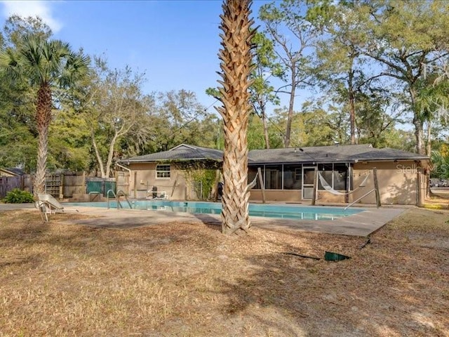 view of pool with a sunroom and a patio area