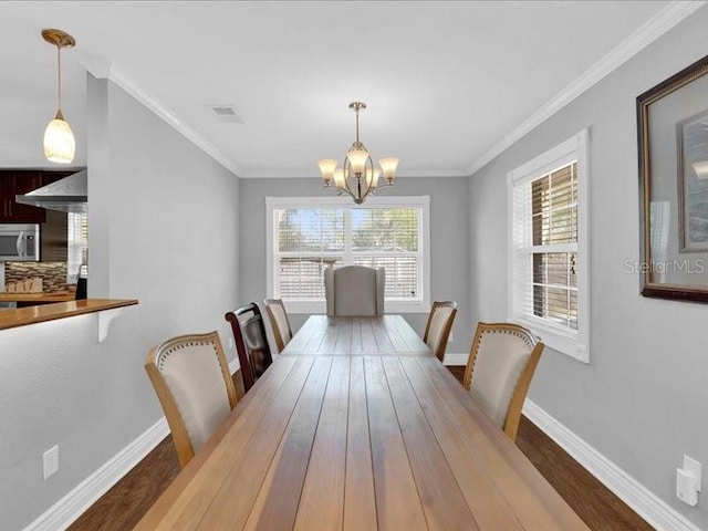 dining area with crown molding, dark wood-type flooring, and a notable chandelier