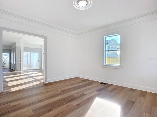 unfurnished room with crown molding and hardwood / wood-style flooring