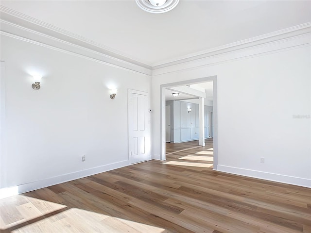 unfurnished room with hardwood / wood-style floors and ornamental molding