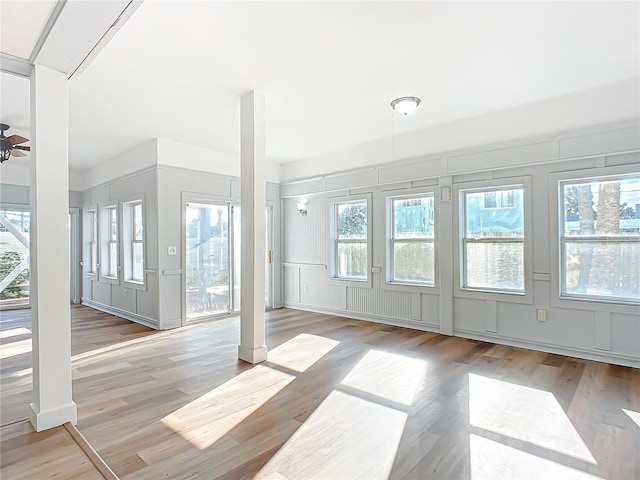 interior space with a wealth of natural light, light hardwood / wood-style flooring, and ceiling fan