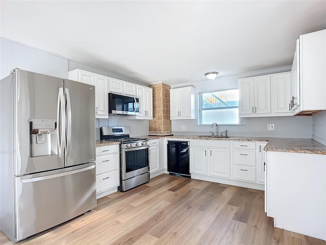 kitchen with white cabinetry, sink, light hardwood / wood-style flooring, and appliances with stainless steel finishes