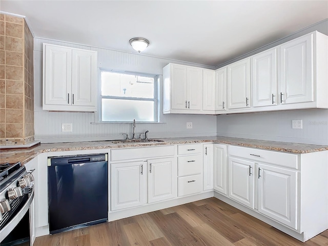 kitchen featuring white cabinets, black dishwasher, light hardwood / wood-style flooring, and sink