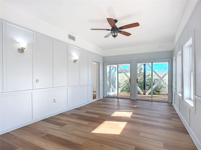 empty room with ceiling fan and dark hardwood / wood-style flooring