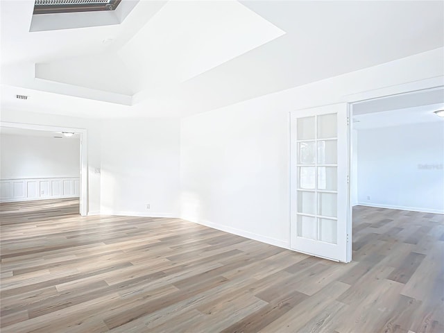 spare room featuring hardwood / wood-style flooring and lofted ceiling