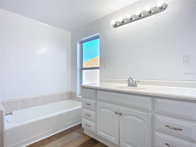 bathroom featuring hardwood / wood-style flooring, vanity, and a tub to relax in