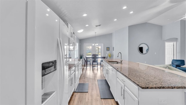 kitchen featuring white appliances, light wood-type flooring, lofted ceiling, white cabinets, and sink