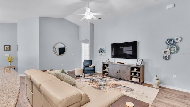 living room featuring ceiling fan, light hardwood / wood-style floors, and vaulted ceiling