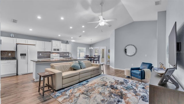 living room with vaulted ceiling, ceiling fan, hardwood / wood-style floors, and sink