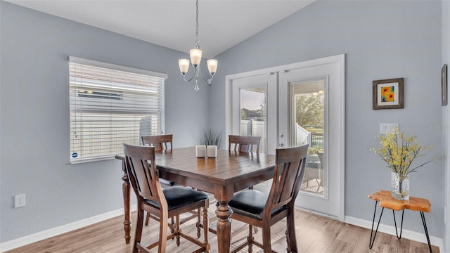 dining area featuring vaulted ceiling, a chandelier, french doors, and light wood-type flooring