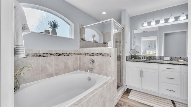 bathroom featuring vanity, wood-type flooring, and shower with separate bathtub