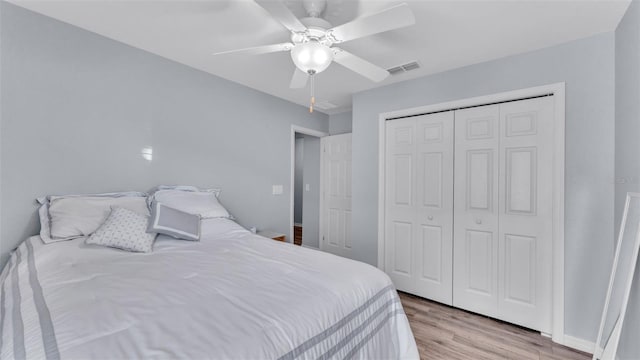 bedroom featuring ceiling fan, light hardwood / wood-style floors, and a closet