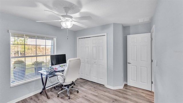 home office with ceiling fan, a wealth of natural light, and light hardwood / wood-style floors