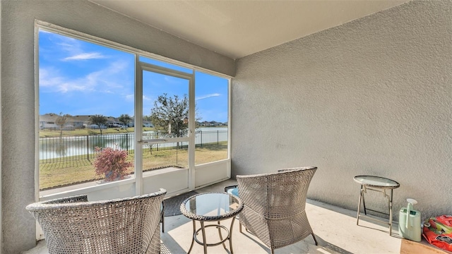 sunroom featuring a water view