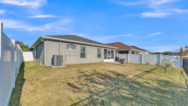 back of property with central air condition unit and a yard