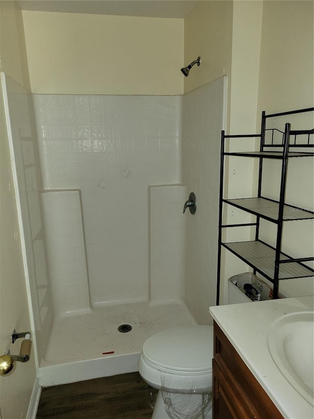 bathroom with hardwood / wood-style flooring, toilet, a shower, and vanity