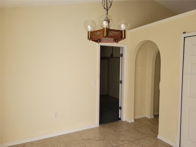 tiled spare room with vaulted ceiling