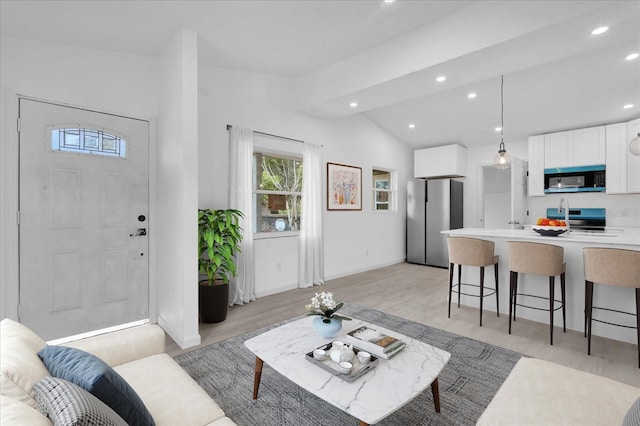 living room featuring light hardwood / wood-style floors and vaulted ceiling