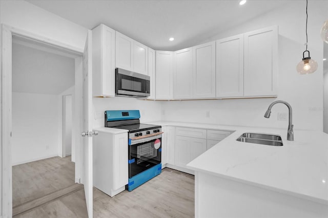 kitchen with white cabinets, sink, hanging light fixtures, vaulted ceiling, and stainless steel appliances