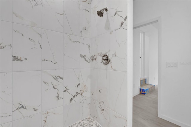 bathroom featuring tiled shower and hardwood / wood-style floors