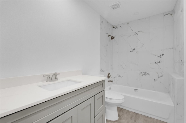 full bathroom with vanity, toilet, wood-type flooring, and tiled shower / bath combo