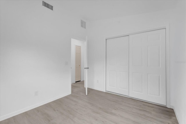 unfurnished bedroom featuring light hardwood / wood-style flooring and a closet