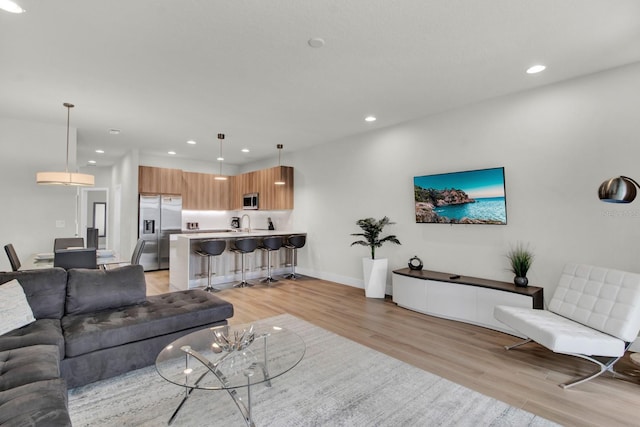 living room with sink and light wood-type flooring