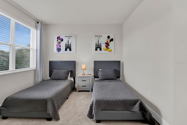 bedroom with light carpet and multiple windows