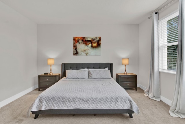 bedroom featuring light carpet and multiple windows