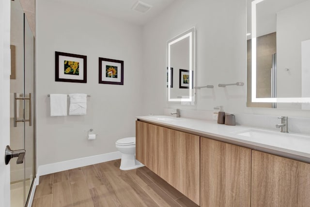 bathroom featuring vanity, toilet, and walk in shower