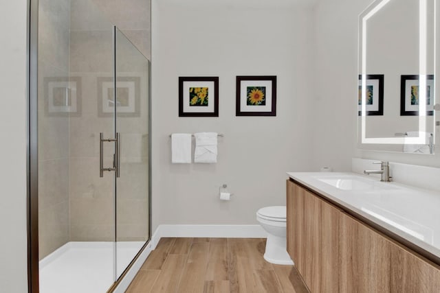 bathroom with vanity, wood-type flooring, an enclosed shower, and toilet